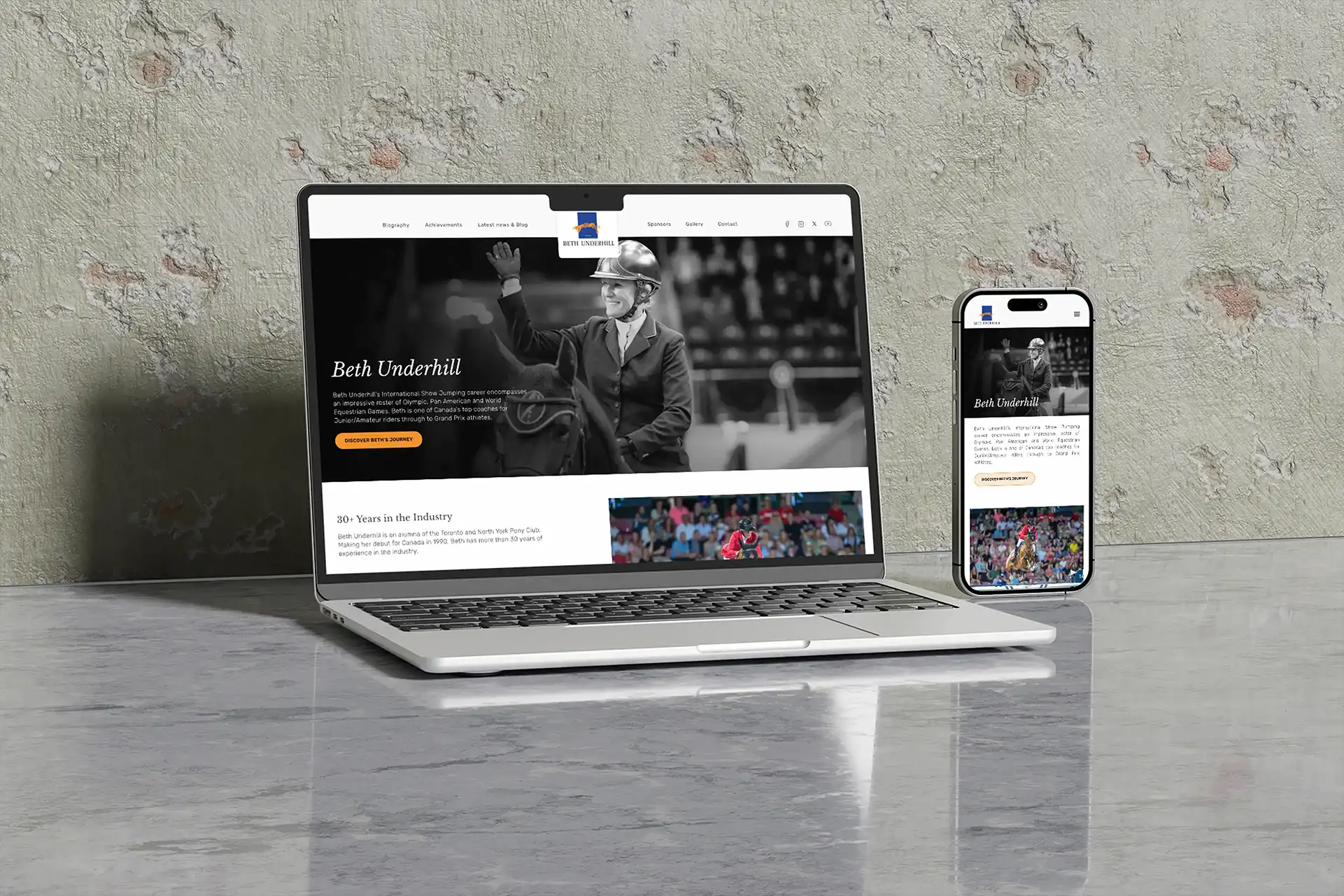 The Beth Underhill website shown on a laptop and iPhone against a concrete wall