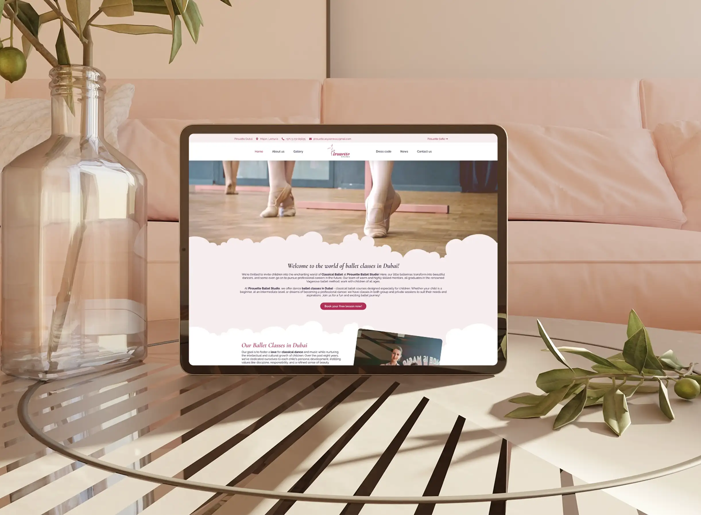 Уебсайтът на Pirouette Studio е на таблет, разположен на стъклена маса в межда розова стая.