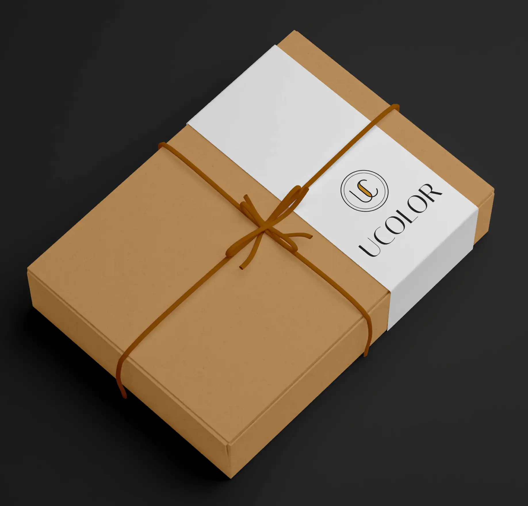 A kraft Ucolor Pro gift box tied with ribbon and a branded band